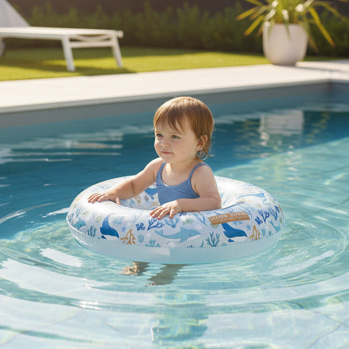 Kleinkind sitzt in einem hochwertigen Baby-Schwimmring und genießt den Badespaß im Pool an einem sonnigen Sommertag. Ideal für erste Wassergewöhnung und entspannte Stunden im Garten.