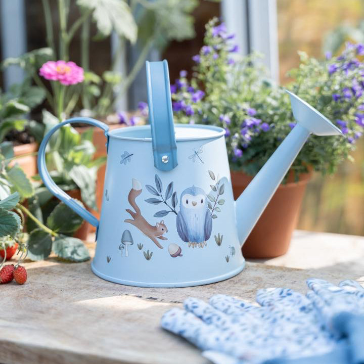 Kinder Gießkanne aus Metall in Blau mit Eulen- und Waldmotiv beim Gießen von Blumen im Garten – ideal für kleine Gärtner ab 3 Jahren.