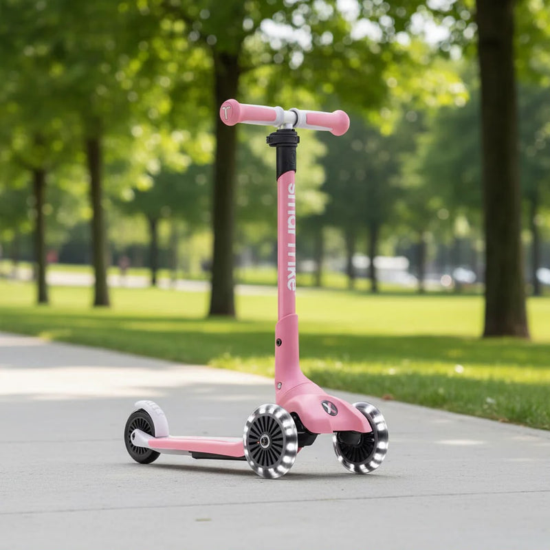 SmarTrike Xtend Scooter in Pink mit LED-Rädern auf einem Gehweg im Park – mitwachsender Kinderroller für Kinder ab 3 Jahren