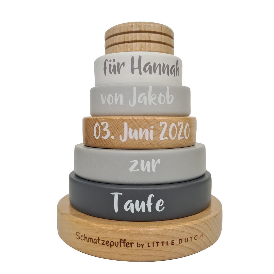 Detailaufnahme eines personalisierten Stapelturms aus Holz mit Name und Datum als Geschenk zur Taufe für Babys