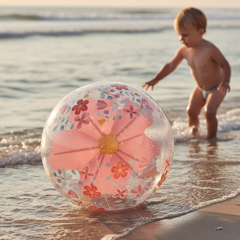 Kind spielt mit Strandball im seichten Wasser am Strand – sommerlicher Spielspaß für Kinder im Urlaub