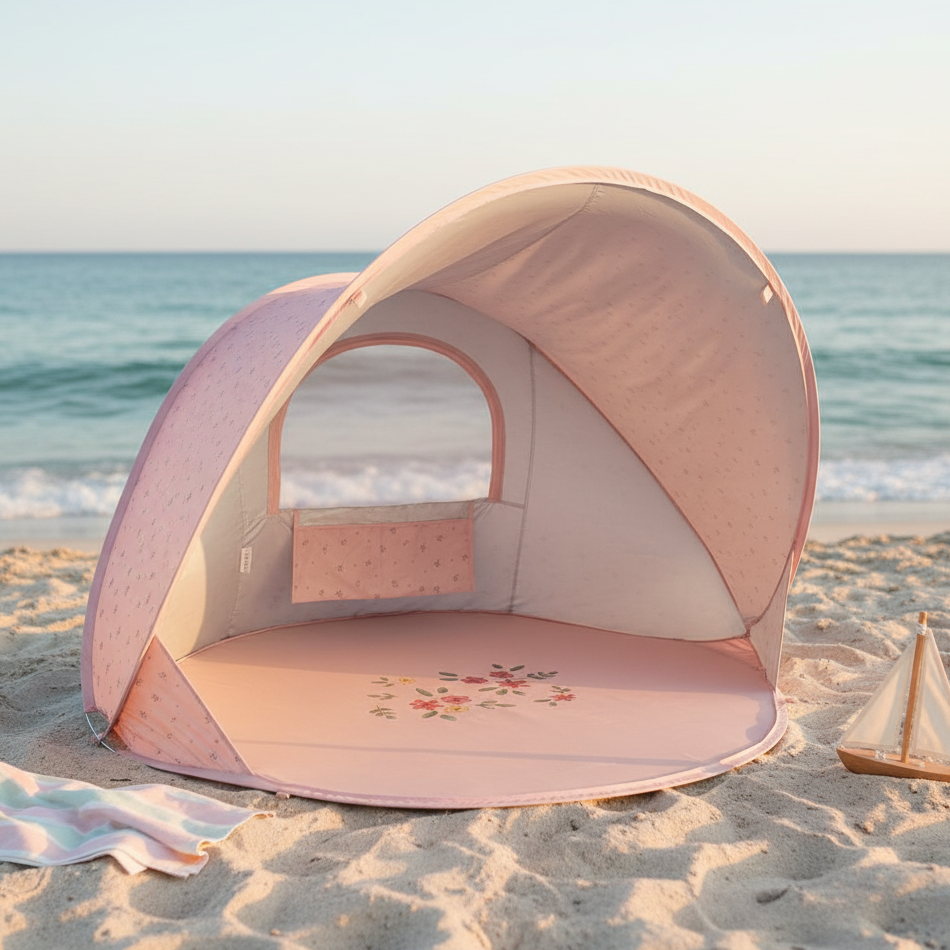 Pinke Strandmuschel für Babys und Kinder am Strand mit Meer im Hintergrund – UV Schutz Pop Up Strandzelt für sicheren Schatten im Sommer